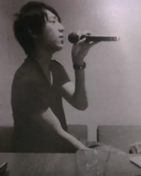 カラオケバーで歌っている小山慶一郎の画像