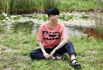 コムアイがサスティナブルなtシャツを着て座っている画像
